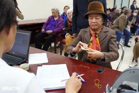 Người phụ nữ lớn tuổi nhận tư vấn về lương hưu hoặc trợ cấp tại bàn làm việc.