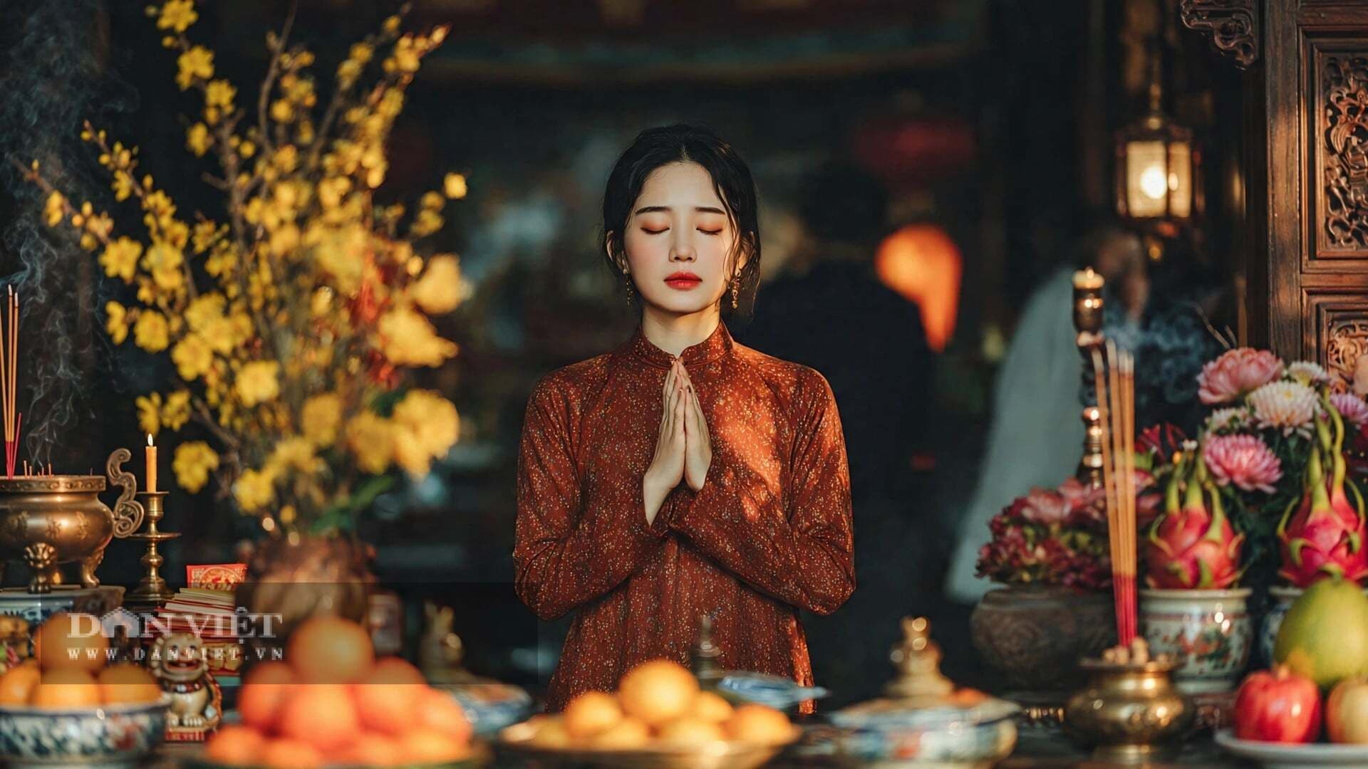 Người phụ nữ mặc áo dài truyền thống chắp tay cầu nguyện trước bàn thờ cúng rằm với hương khói và lễ vật, thể hiện lòng thành kính và sự kết nối tâm linh.