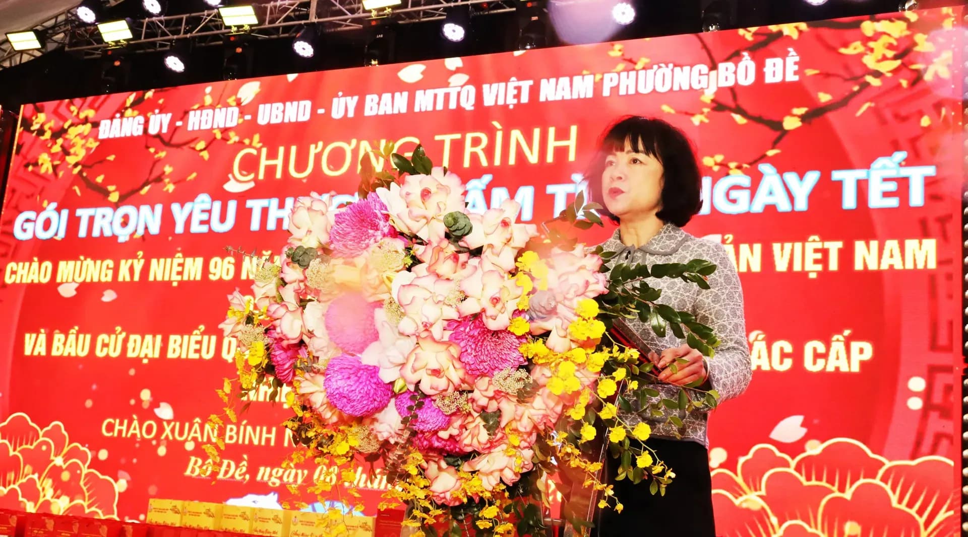 Người phụ nữ phát biểu tại chương trình "Gói trọn yêu thương – Ấm tình ngày Tết", nhấn mạnh tinh thần đoàn kết và sẻ chia.