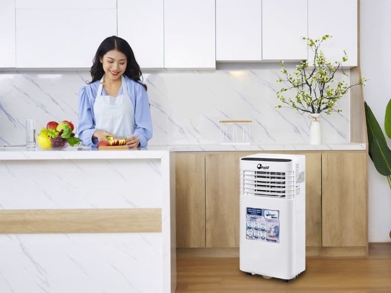 Người phụ nữ sử dụng điều hòa di động, minh họa cách chuẩn bị đối phó với nắng nóng gay gắt