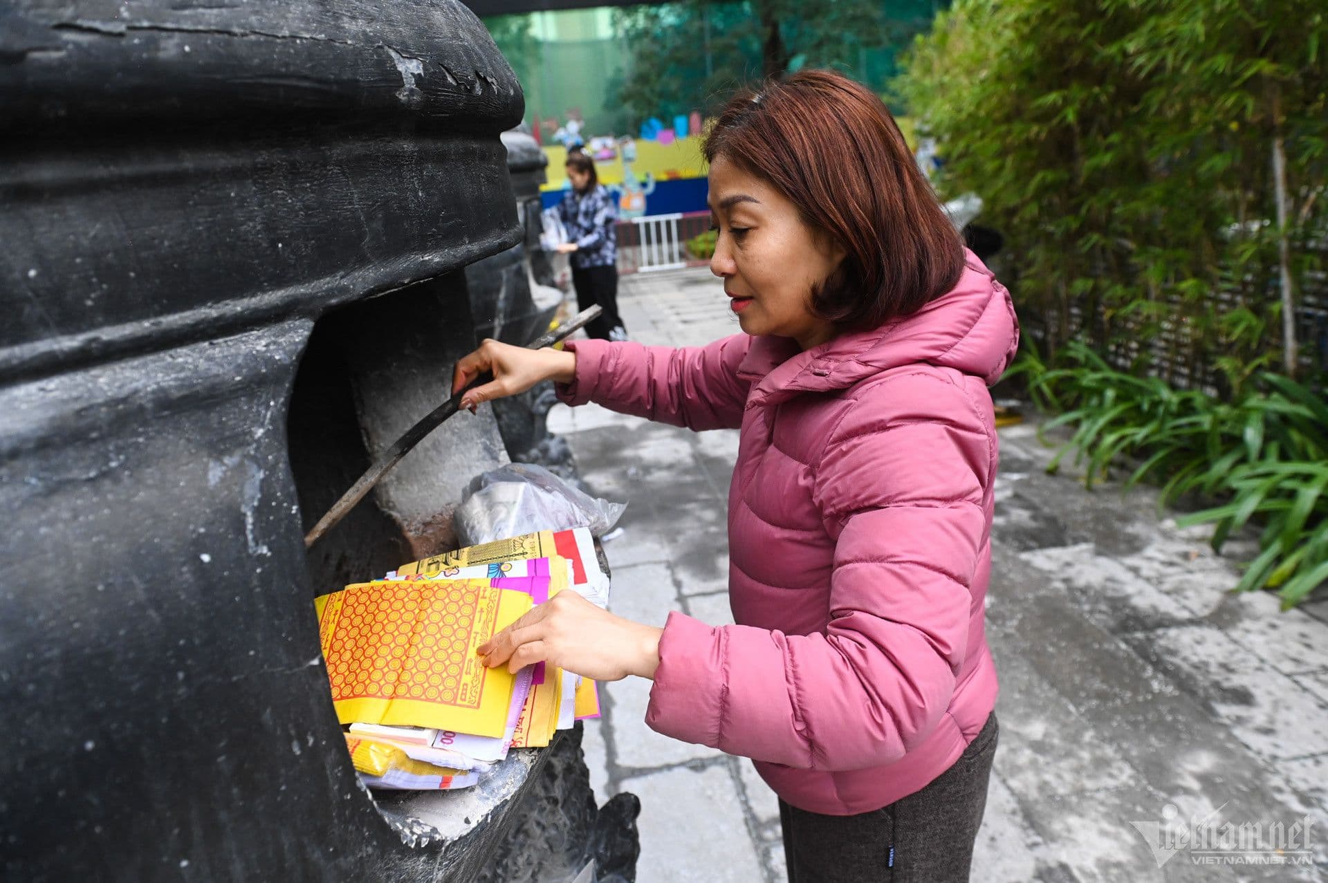 Người phụ nữ thực hiện nghi lễ hóa vàng, đốt vàng mã tiễn biệt tổ tiên vào Mùng 3 Tết.