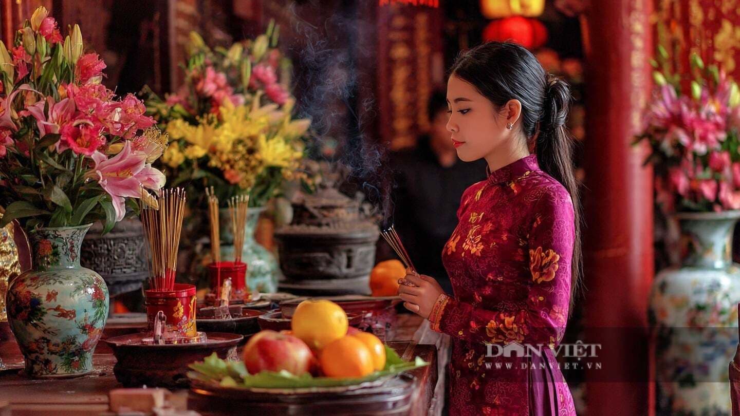 Người phụ nữ thực hiện nghi thức văn khấn, tâm hồn lắng đọng để bày tỏ ước nguyện và kết nối với cội nguồn.