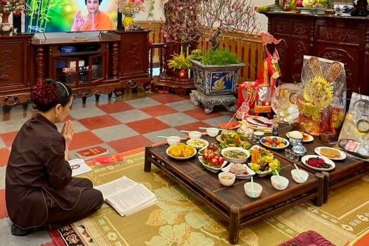 Người phụ nữ thành tâm cầu nguyện trước mâm cỗ cúng Ông Công Ông Táo