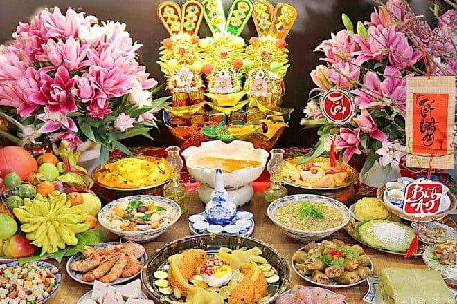 Người phụ nữ thành tâm khấn vái trước bàn thờ trong lễ cúng ông Công ông Táo