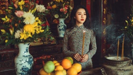Người phụ nữ Việt Nam mặc áo dài truyền thống thắp hương, thể hiện lòng thành kính và lời khấn nguyện trong dịp Tết Hàn thực.