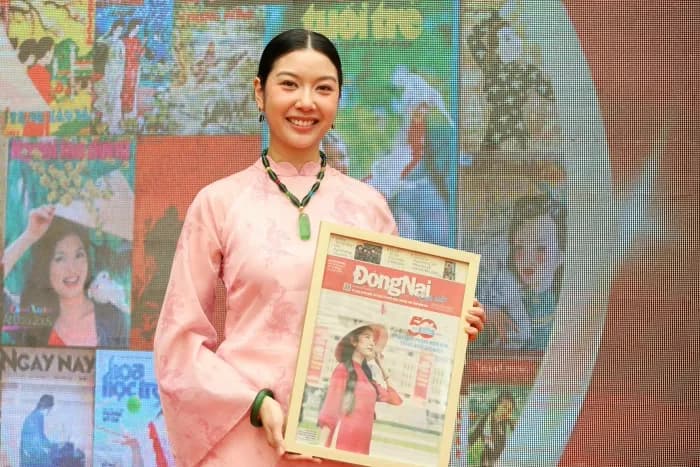 Người phụ nữ Việt Nam trong trang phục áo dài truyền thống cầm tờ báo xuân xưa, gợi nhớ về những ký ức và di sản văn hóa Tết.