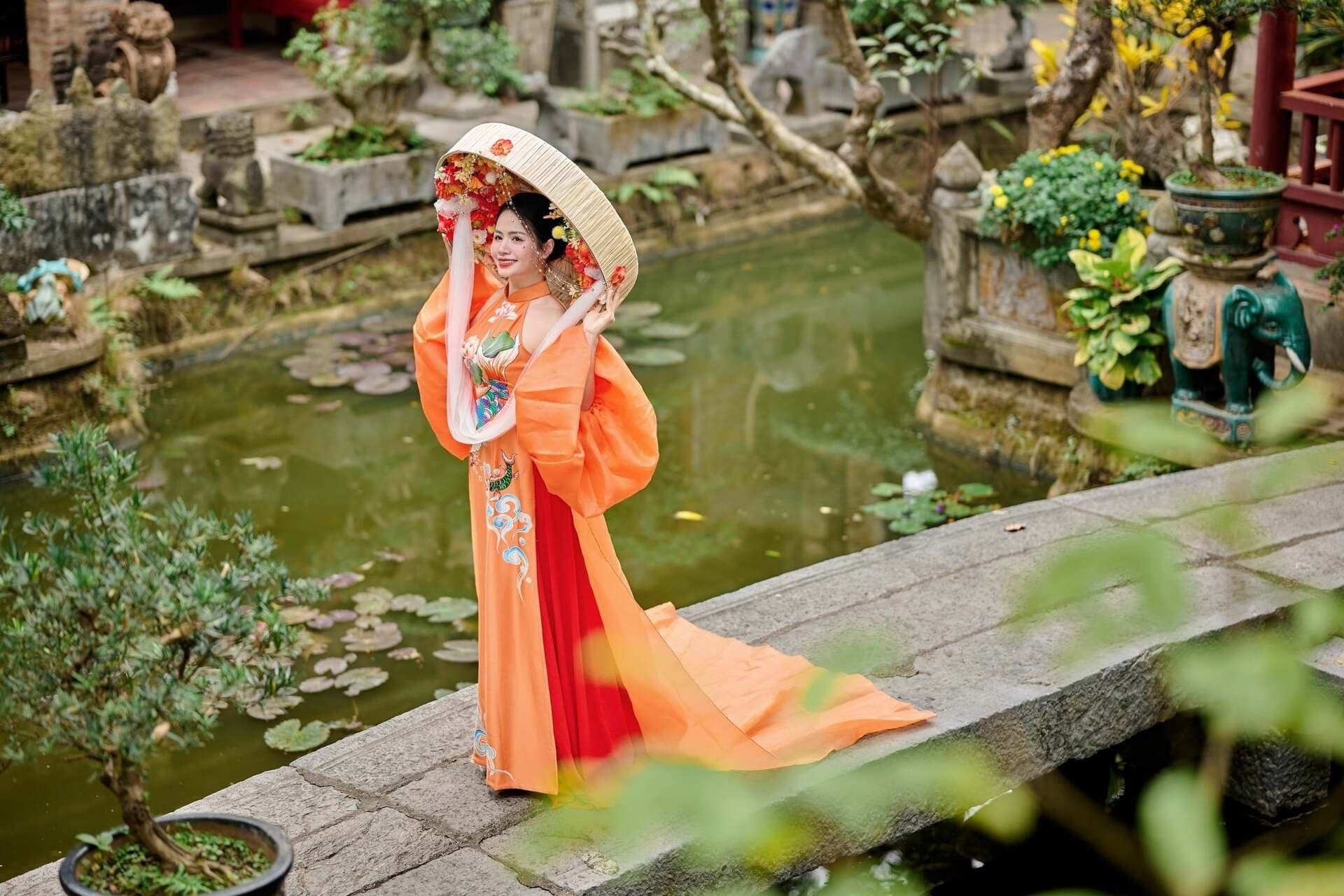 Người phụ nữ Việt trong trang phục áo dài truyền thống, tạo dáng thanh thoát bên hồ nước, gợi lên vẻ đẹp văn hóa và sự bình yên