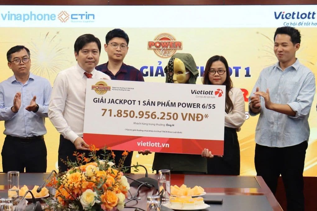 Người trúng giải Vietlott Jackpot nhận tấm séc 71,8 tỷ đồng, tượng trưng cho giấc mơ đổi đời.