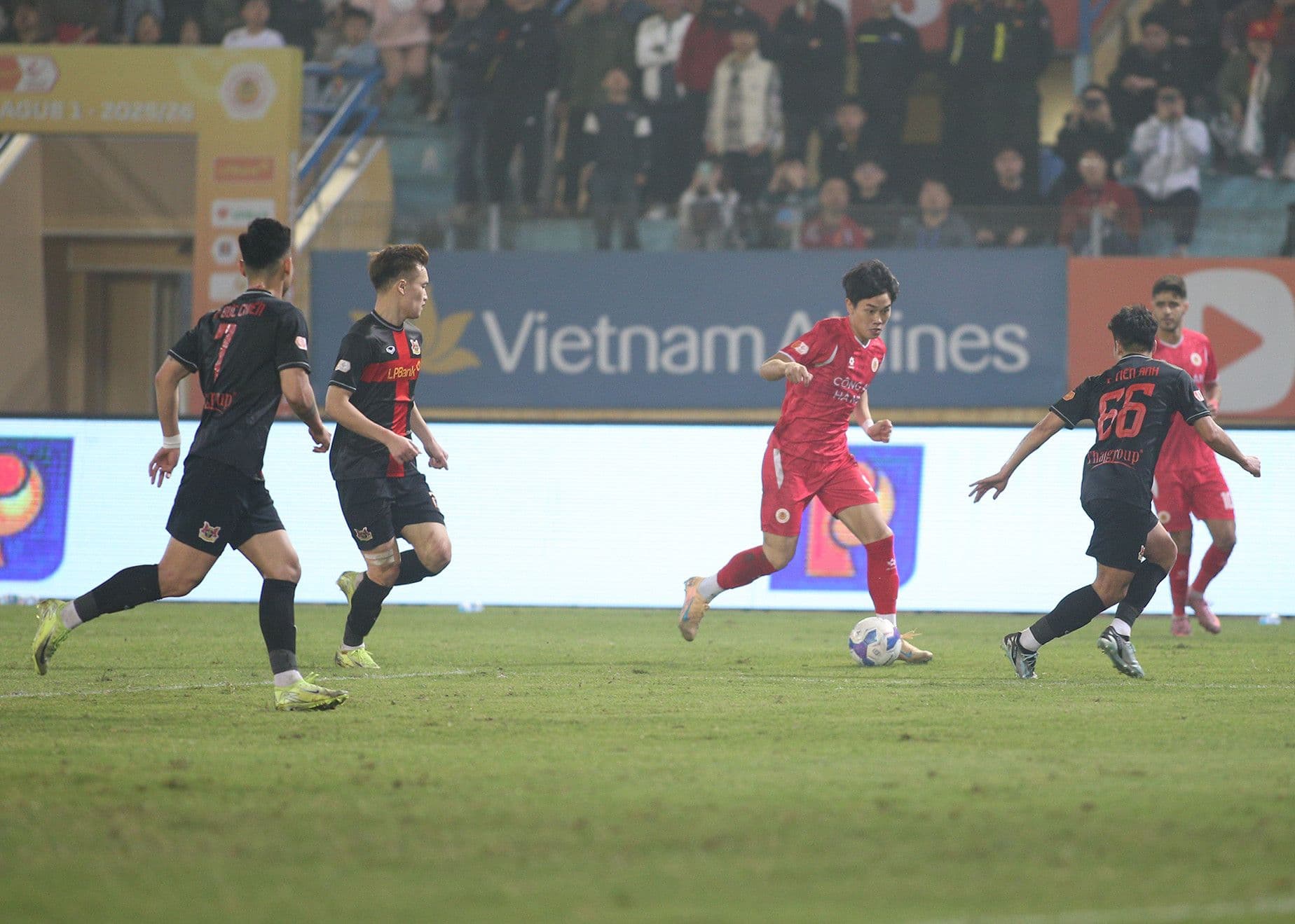 Nguyễn Đình Bắc thể hiện tốc độ và kỹ thuật cá nhân khi đi bóng qua các cầu thủ đối phương trong trận đấu V-League.