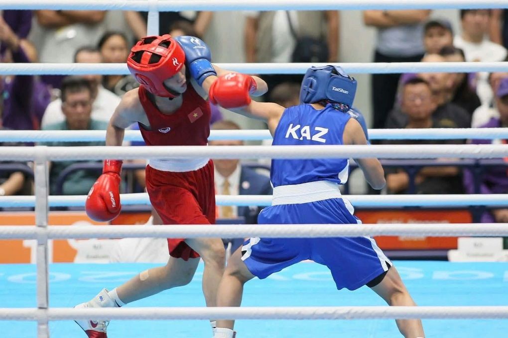 Nguyễn Thị Tâm (đai đỏ) tung cú đấm vào đối thủ Kazakhstan, thể hiện bản lĩnh vượt qua nhà vô địch thế giới.