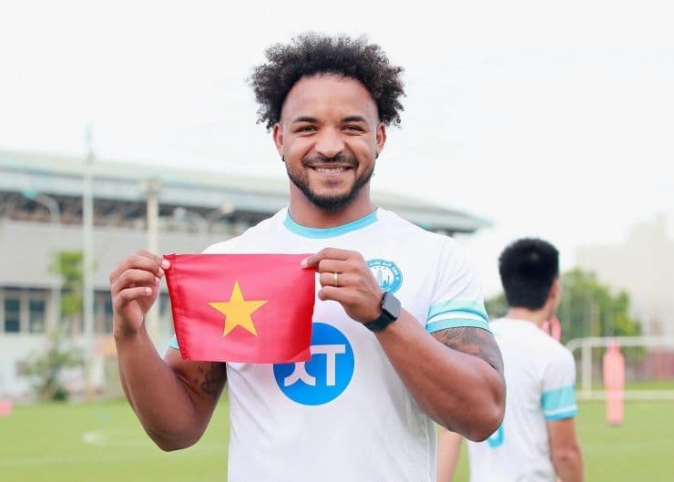 Nguyễn Xuân Son mỉm cười tự hào cầm lá cờ Việt Nam, thể hiện tình yêu với quê hương thứ hai.