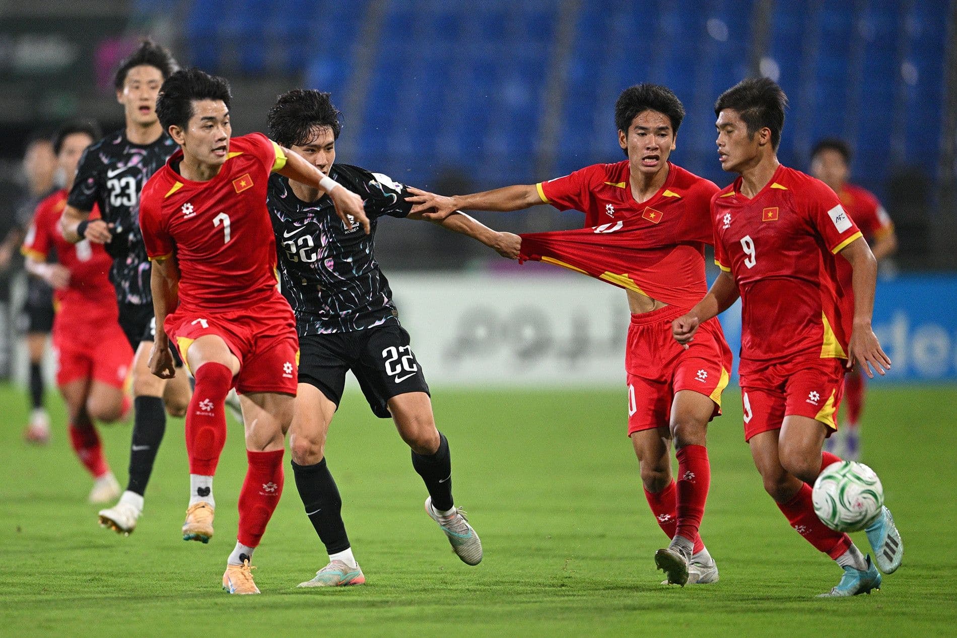 Đình Bắc và đồng đội đối mặt với sự truy cản quyết liệt từ cầu thủ đối phương, tượng trưng cho những rào cản khi xuất ngoại.