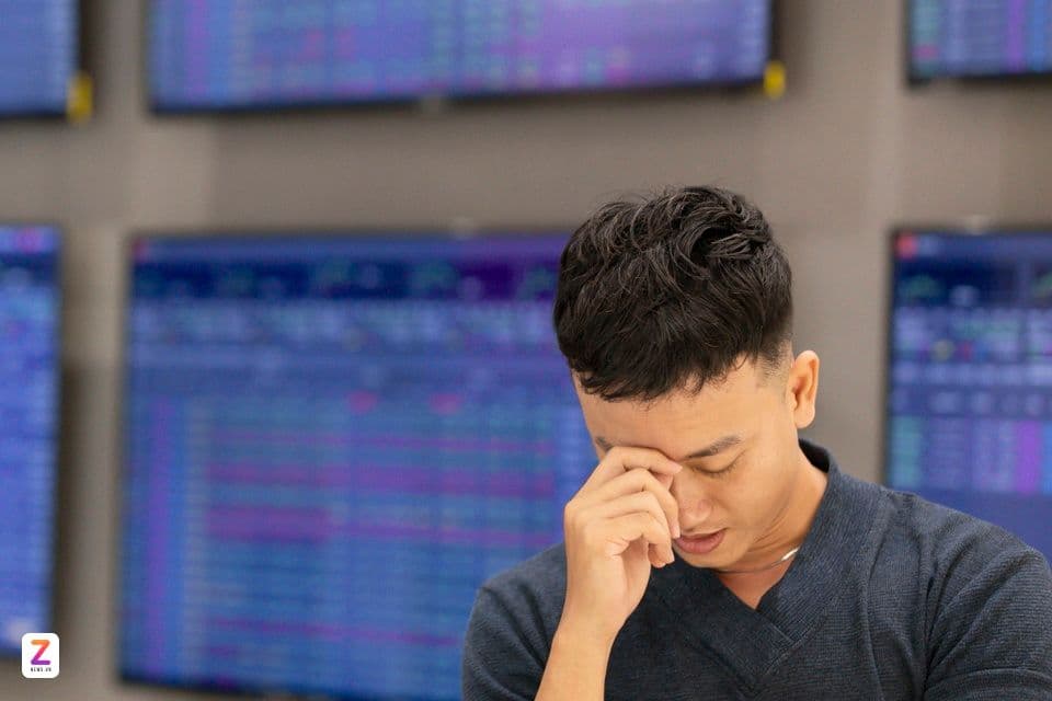 Nhà đầu tư lo lắng nhìn màn hình chứng khoán đỏ lửa
