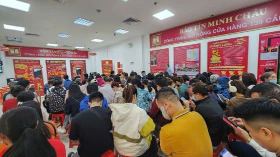 Nhiều người đang tập trung vào điện thoại di động trong một không gian đông đúc, tượng trưng cho dòng chảy thông tin 24h không ngừng nghỉ.