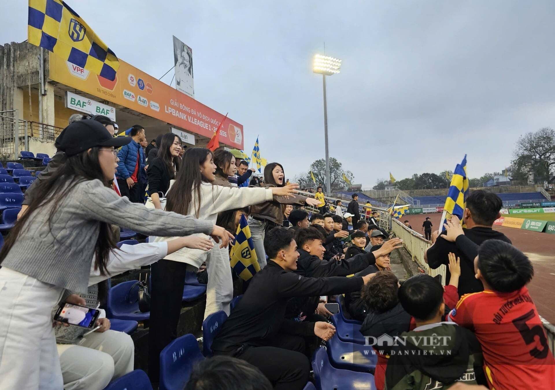 Nhóm cổ động viên Sông Lam Nghệ An trẻ tuổi hò reo cổ vũ trên khán đài, thể hiện sự nhiệt huyết và kỳ vọng vào đội bóng.