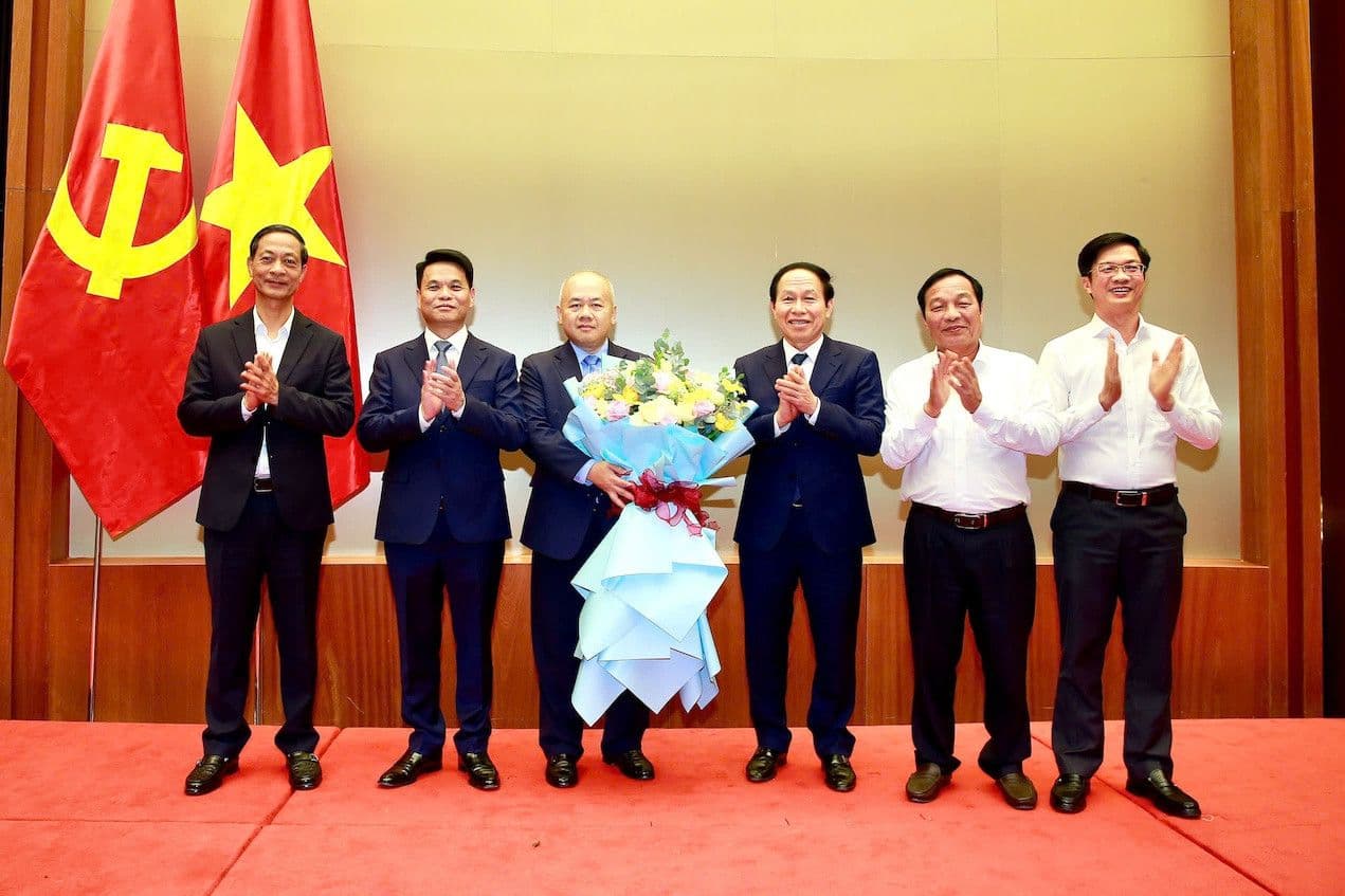 Nhóm các quan chức tại một buổi lễ trang trọng, tượng trưng cho sự kiện quan trọng hoặc sự hợp tác trong tổ chức giáo dục.