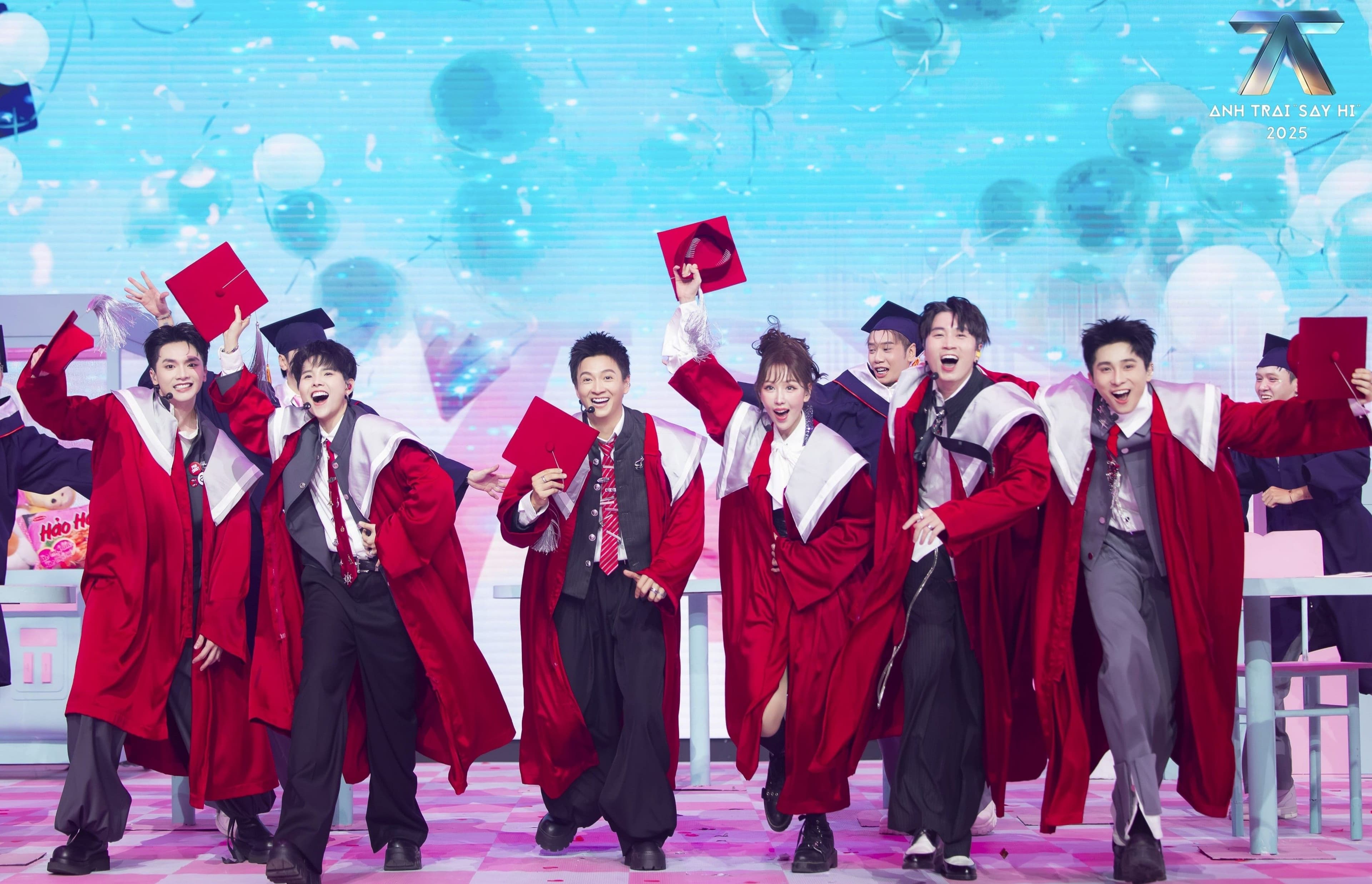 Nhóm Ngô Kiến Huy trình diễn ca khúc 'Hơn Là Bạn' với trang phục áo choàng đỏ và mũ cử nhân trên sân khấu chủ đề trường học.