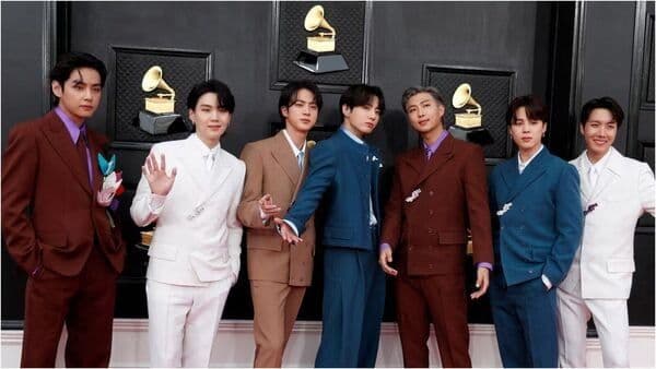 Nhóm nhạc BTS gồm 7 thành viên tạo dáng trên thảm đỏ, tượng trưng cho sự trở lại với album Arirang.