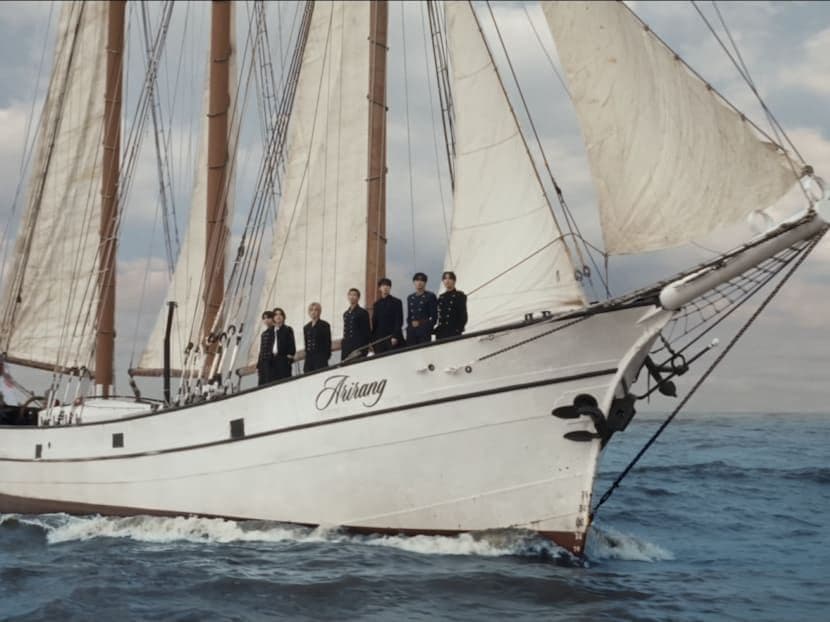 Nhóm nhạc BTS trên con tàu 'Arirang' giữa biển khơi, biểu tượng cho sự trở lại với album 'SWIM'.