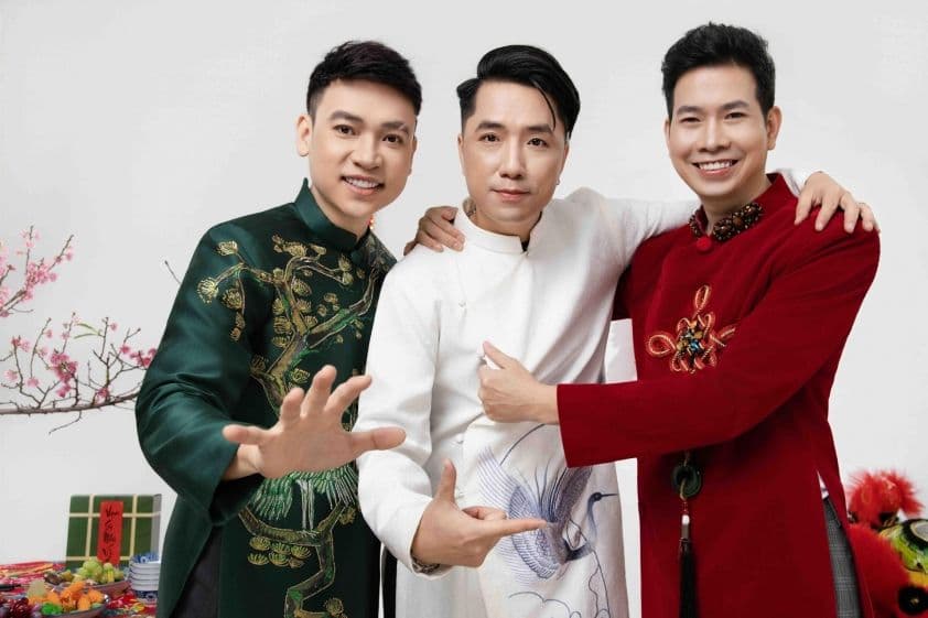 Nhóm Tre Papa tươi cười trong trang phục áo dài truyền thống, với phông nền Tết ấm áp, thể hiện niềm vui và sự chữa lành mà nhạc xuân mang lại.
