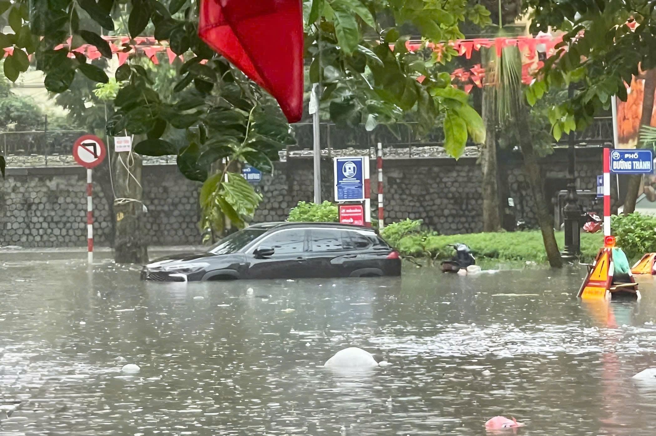 Nhân viên công ty thoát nước Hà Nội hì hục bơm nước trên đường phố ngập lụt.