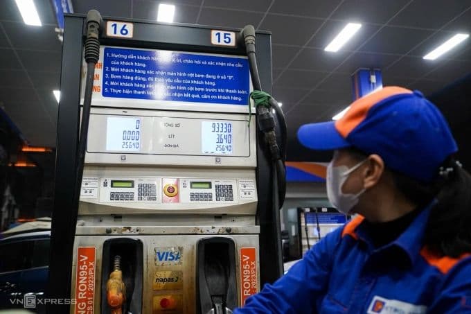 Nhân viên cây xăng cập nhật bảng giá mới, thể hiện sự điều chỉnh giá xăng dầu.