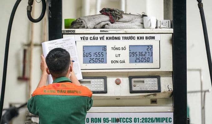 Nhân viên cây xăng cập nhật giá xăng dầu sau đợt điều chỉnh giảm giá