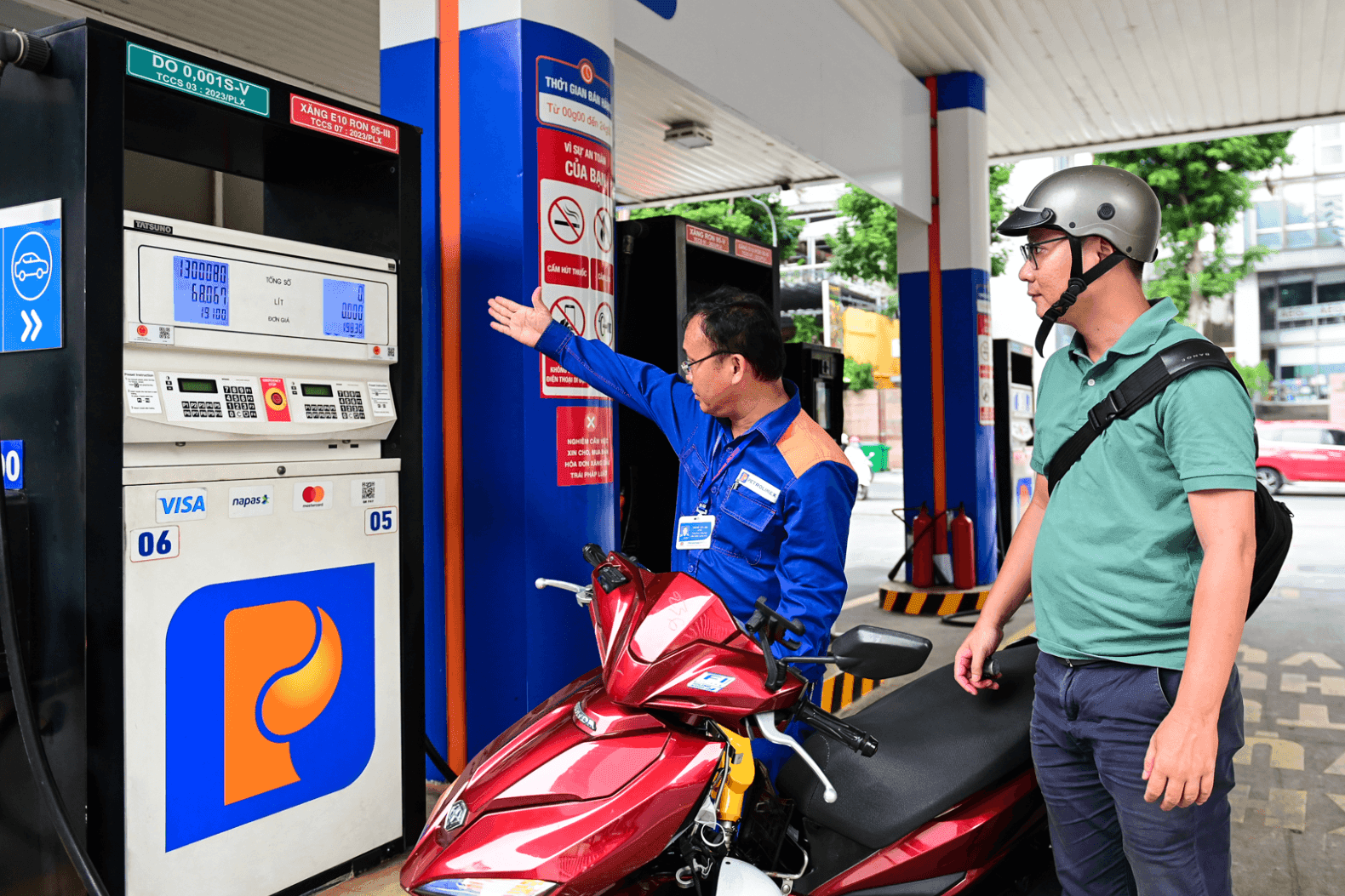 Nhân viên cây xăng hướng dẫn khách hàng, thể hiện quy trình vận hành và chi tiêu từ Quỹ Bình ổn giá xăng dầu.