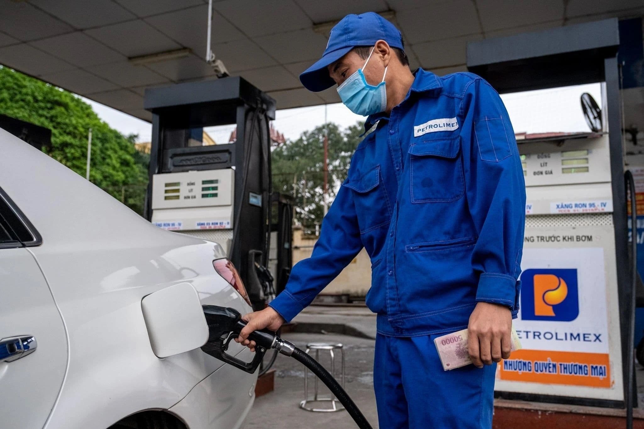Nhân viên cây xăng Petrolimex đang đổ xăng vào ô tô, tượng trưng cho quá trình cung cấp nhiên liệu và các chi phí cấu thành giá.