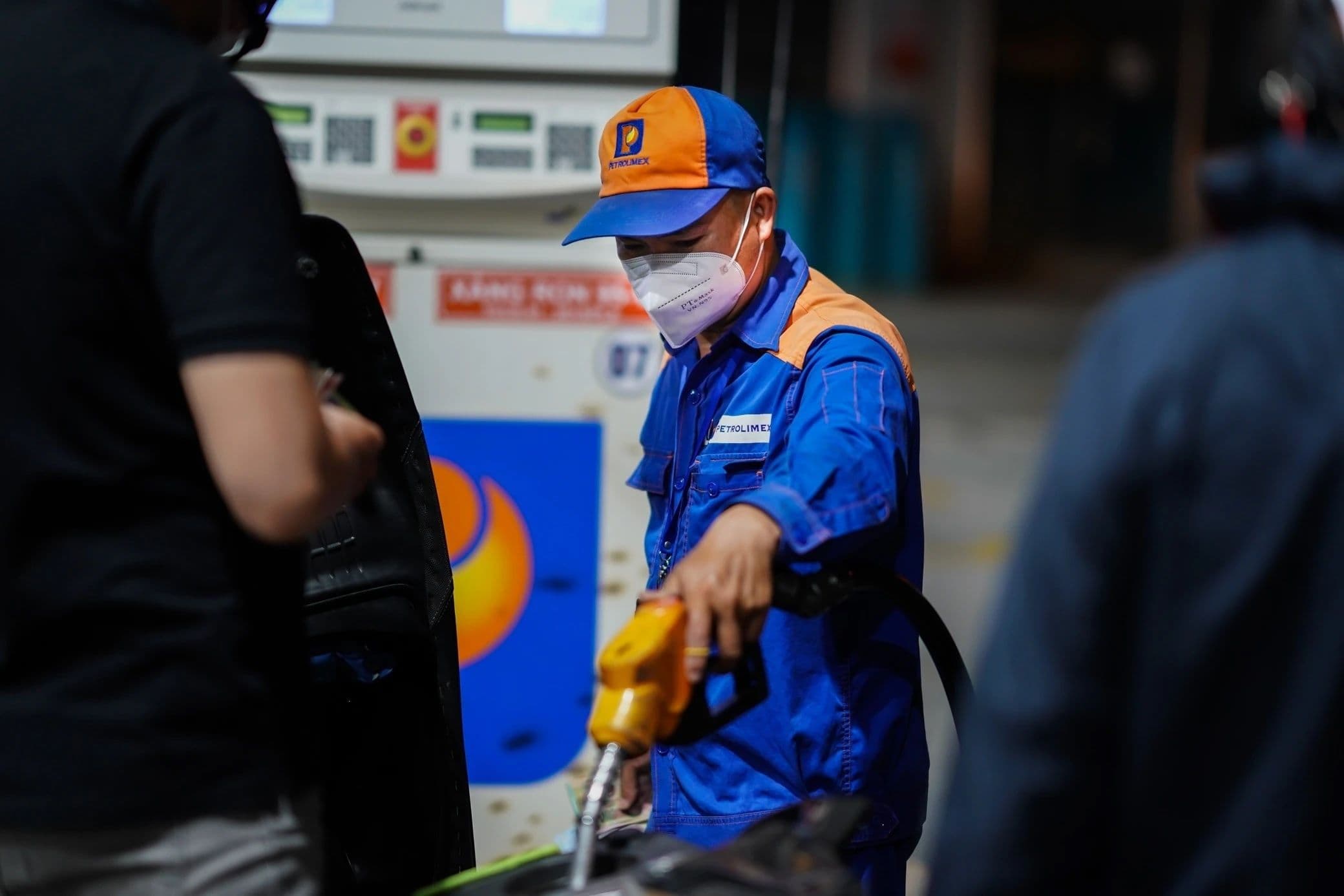 Nhân viên cây xăng Petrolimex phục vụ khách hàng, liên quan đến quyết định không sử dụng Quỹ Bình ổn giá và chính sách thuế 0%.