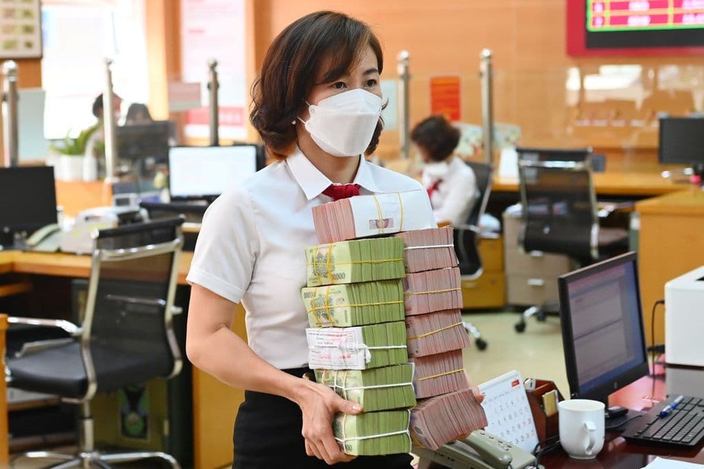 Nhân viên ngân hàng đang vận chuyển các cọc tiền mặt, tượng trưng cho hoạt động gửi và rút tiền, lãi suất hấp dẫn.