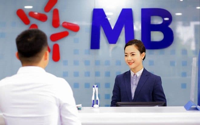 Nhân viên ngân hàng MB chào đón khách hàng, tượng trưng cho dịch vụ và hoạt động của MBB sau thông báo chia cổ tức 35%.