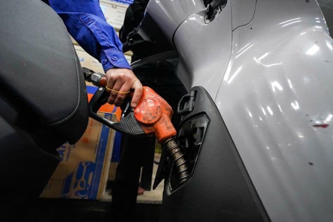 Nhân viên Petrolimex bơm xăng cho xe máy, minh họa hoạt động kinh doanh nhiên liệu.