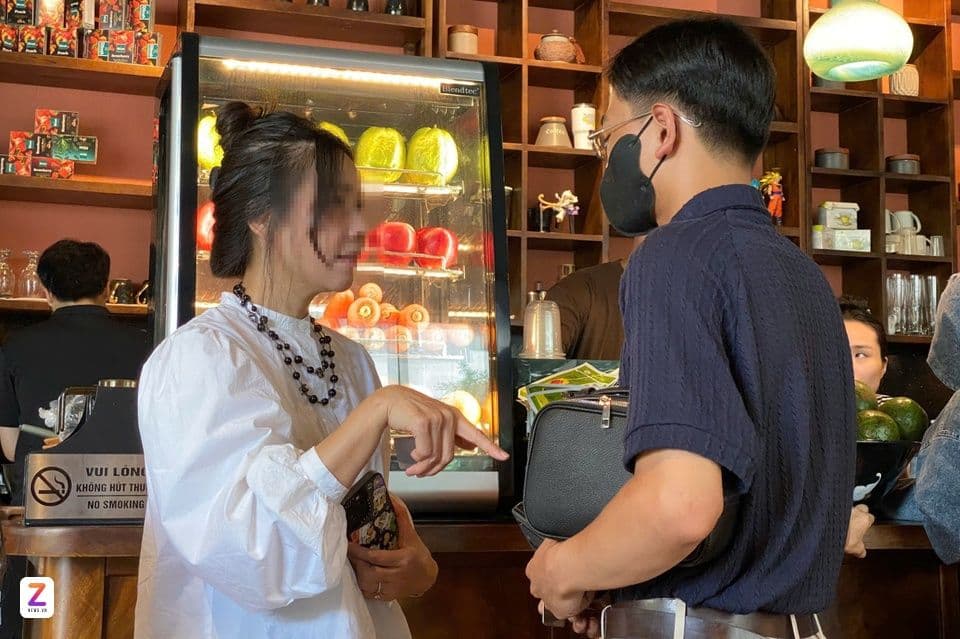 Nhân viên quán cà phê nhắc nhở khách hàng về quy định cấm hút thuốc.