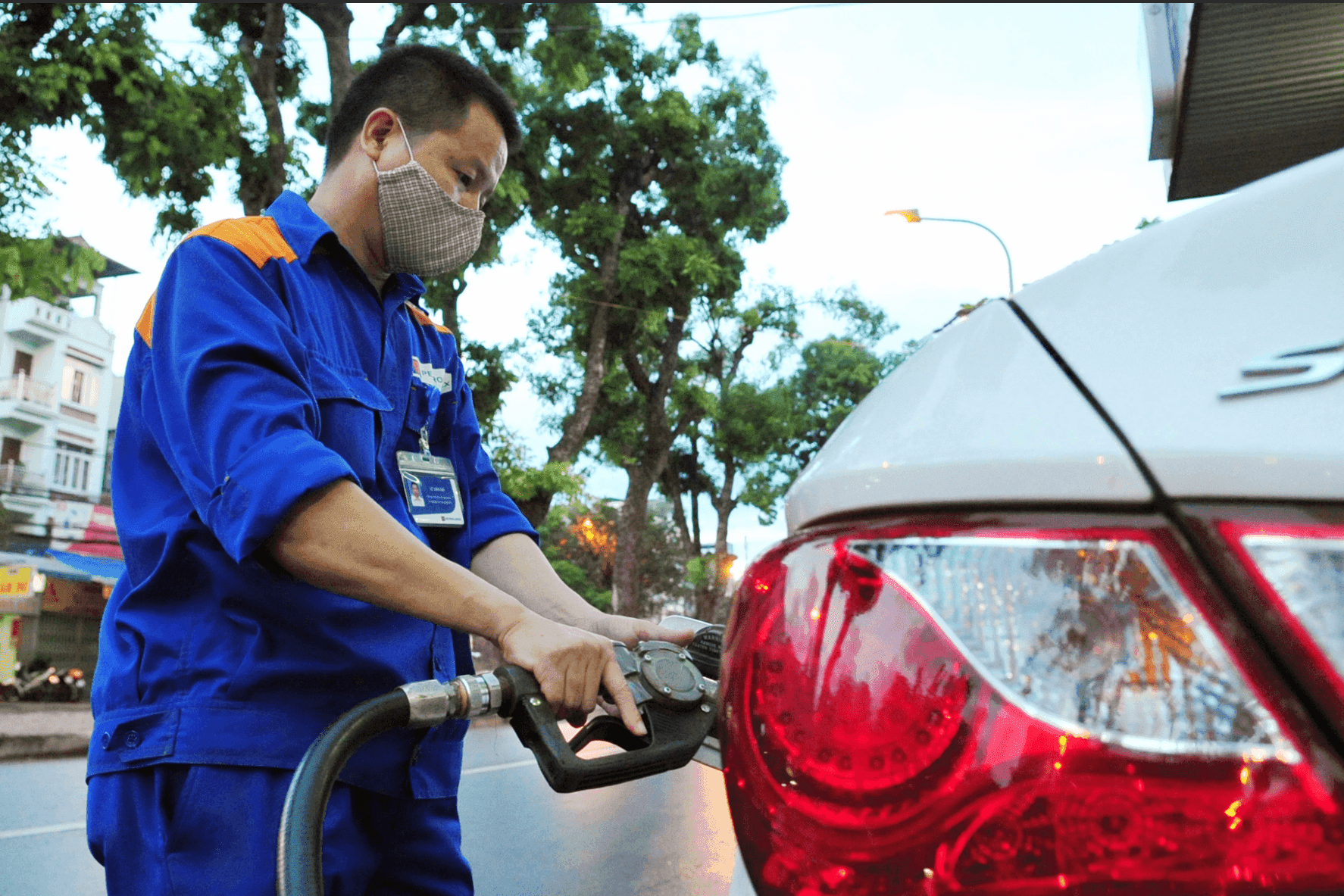 Nhân viên đổ xăng cho ô tô, minh họa việc thực thi các quy định mới về quản lý Quỹ Bình ổn giá xăng dầu.