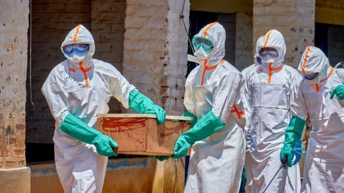 Nhân viên y tế mặc đồ bảo hộ khiêng quan tài chứa thi thể nạn nhân Ebola tại Cộng hòa Dân chủ Congo.