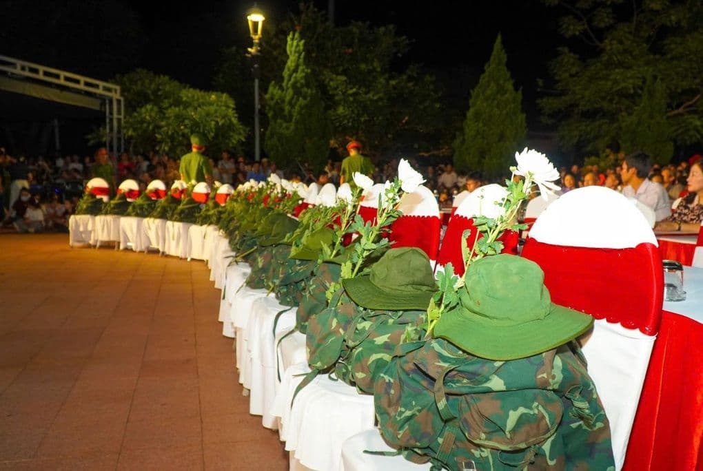 Những bộ quân phục và mũ lính được đặt trang trọng tại buổi chiếu phim 'Mưa Đỏ', gợi nhớ về sự hy sinh của người lính.