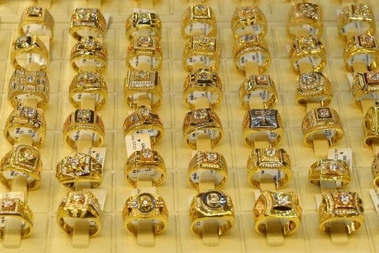 Những chiếc nhẫn vàng trơn trưng bày, tượng trưng cho loại tài sản đang có biến động giá mạnh và vai trò tương lai của vàng.