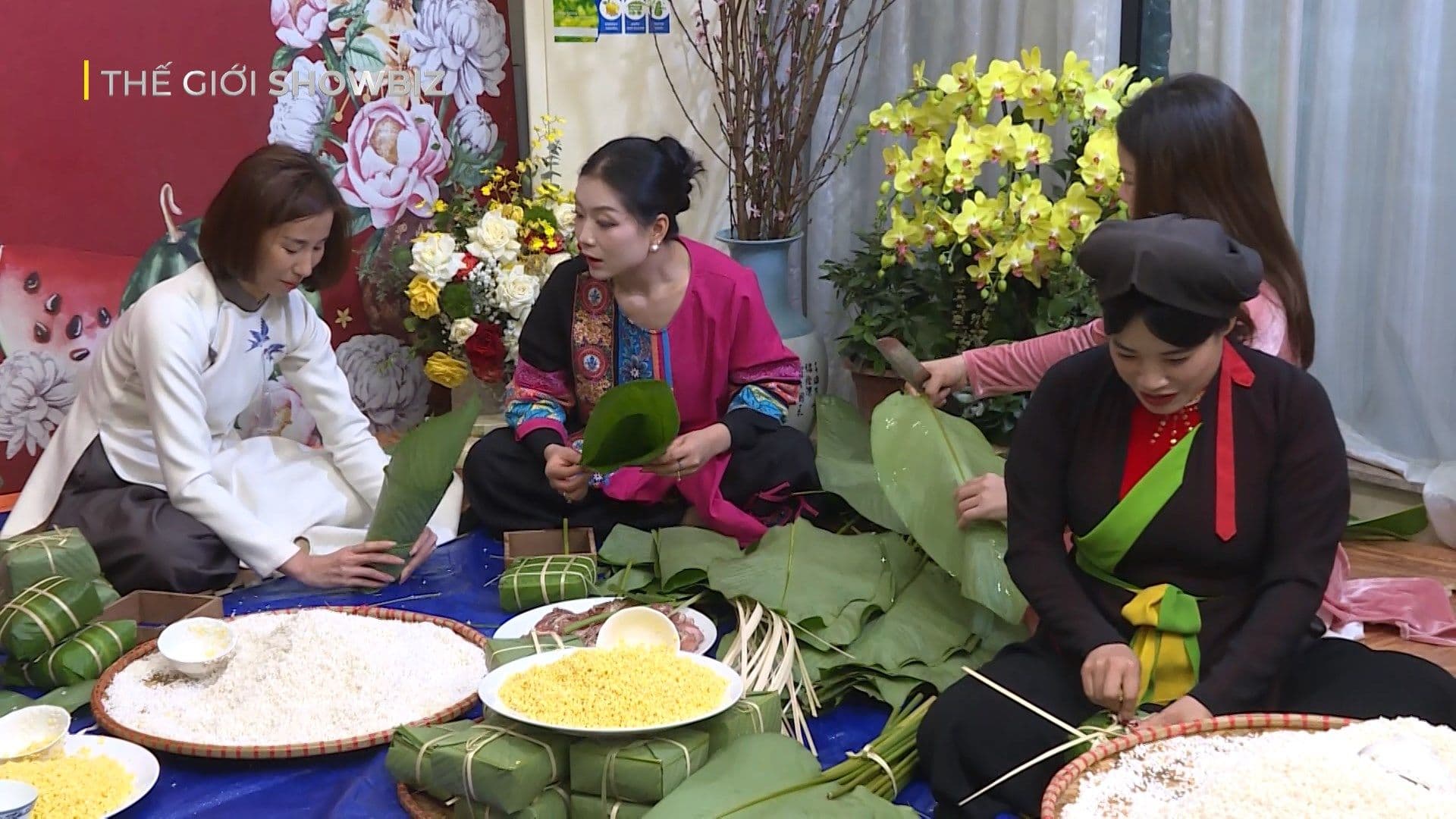Những người phụ nữ Việt đang chuẩn bị nguyên liệu và gói bánh chưng, với gạo nếp, đậu xanh và lá dong được bày biện cẩn thận.