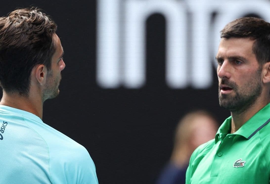 Novak Djokovic đối mặt với đối thủ, thể hiện sự tập trung và bản lĩnh của một huyền thoại quần vợt.