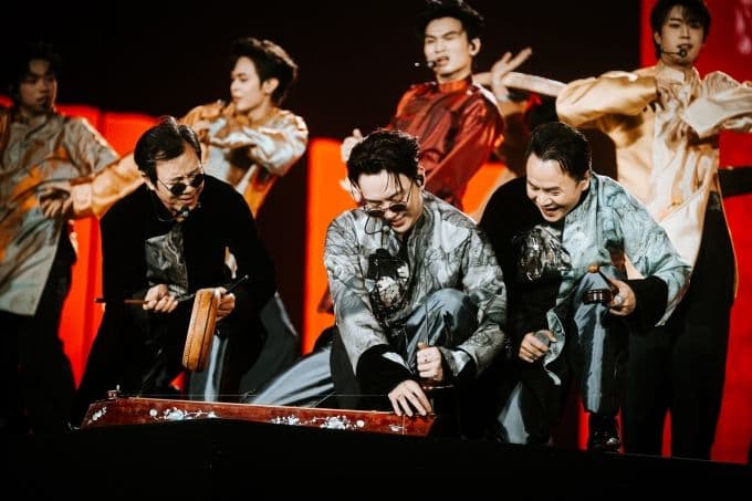 NSND Huỳnh Tú, Soobin Hoàng Sơn và Binz biểu diễn đàn bầu và hát xẩm trên sân khấu, kết hợp truyền thống và hiện đại.