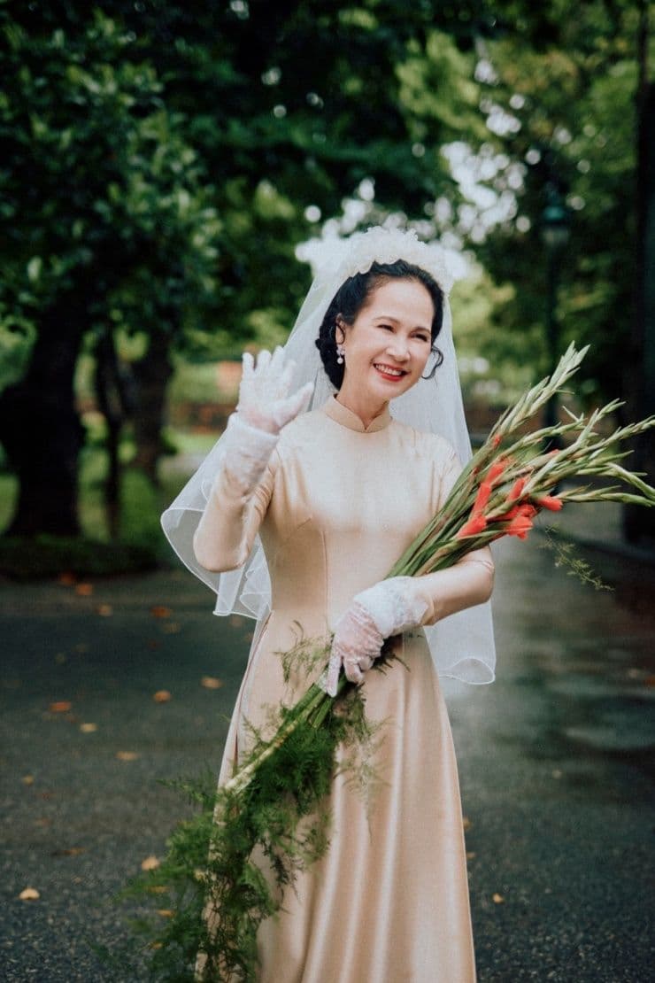 NSND Lan Hương tươi cười vẫy tay trong trang phục cưới xưa, biểu tượng cho di sản truyền cảm hứng về tình yêu và đạo đức nghề nghiệp.