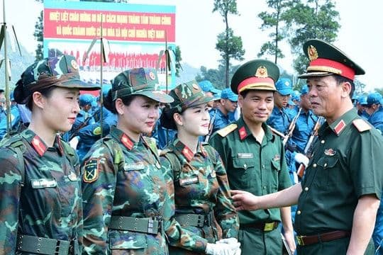 Đoàn quân nhân Việt Nam trong trang phục quân đội, với biểu ngữ chào mừng Cách mạng Tháng Tám và Quốc khánh.