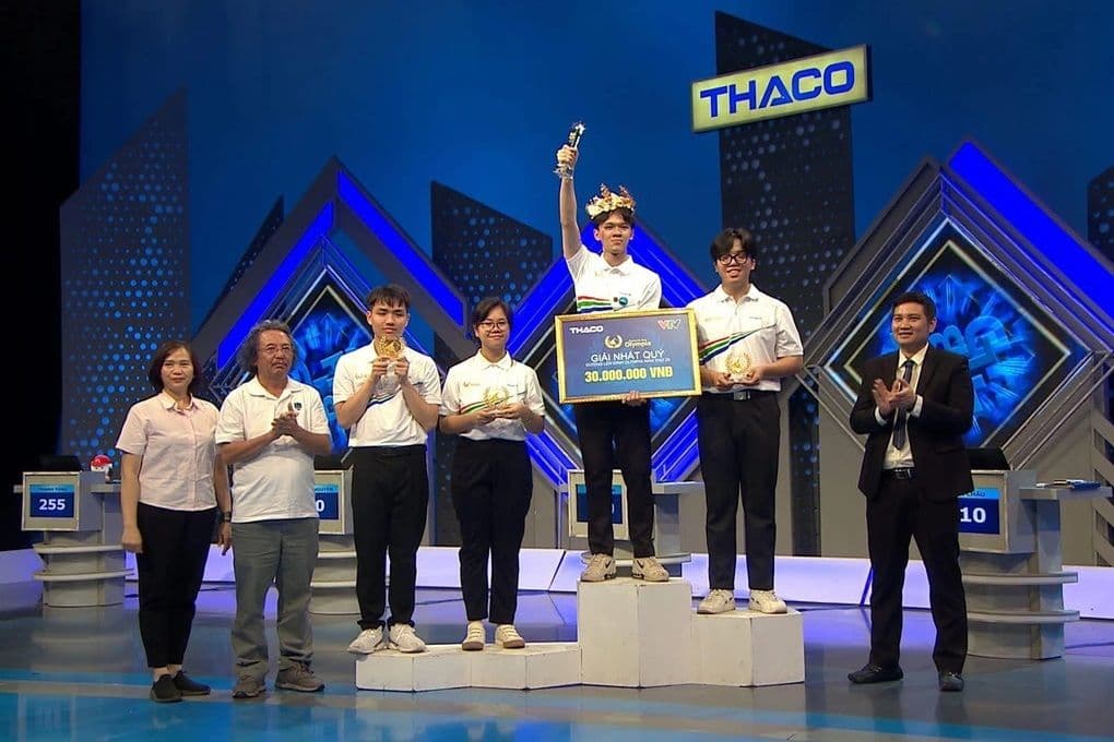Đoàn Thanh Tùng đứng trên bục vinh quang cùng các thí sinh khác và ban tổ chức sau chiến thắng.