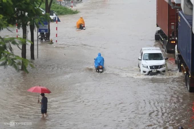 Đoàn xe tang lễ chật vật di chuyển qua đường phố Hà Nội ngập sâu sau bão Kajiki.