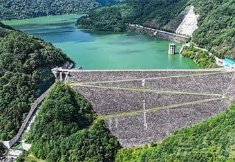 Đập nước lớn giữa núi rừng, gợi liên tưởng đến sức mạnh của các khối nước lớn và mối nguy hiểm tiềm tàng từ đại dương.
