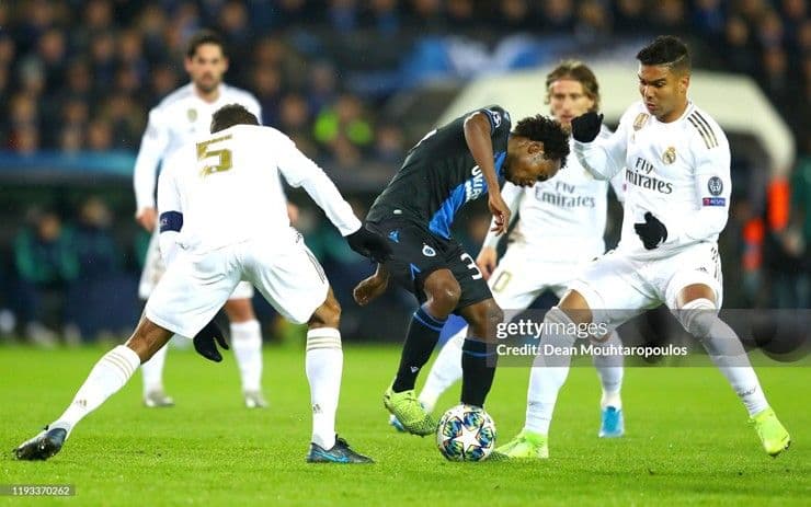 Percy Tau (áo xanh đen) đối đầu các cầu thủ Real Madrid trong trận đấu Champions League.