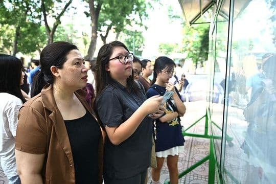 Phụ huynh và học sinh xem thông tin tuyển sinh, thể hiện sự chuẩn bị và tìm hiểu lộ trình ôn luyện cho kỳ thi tiếng Anh.