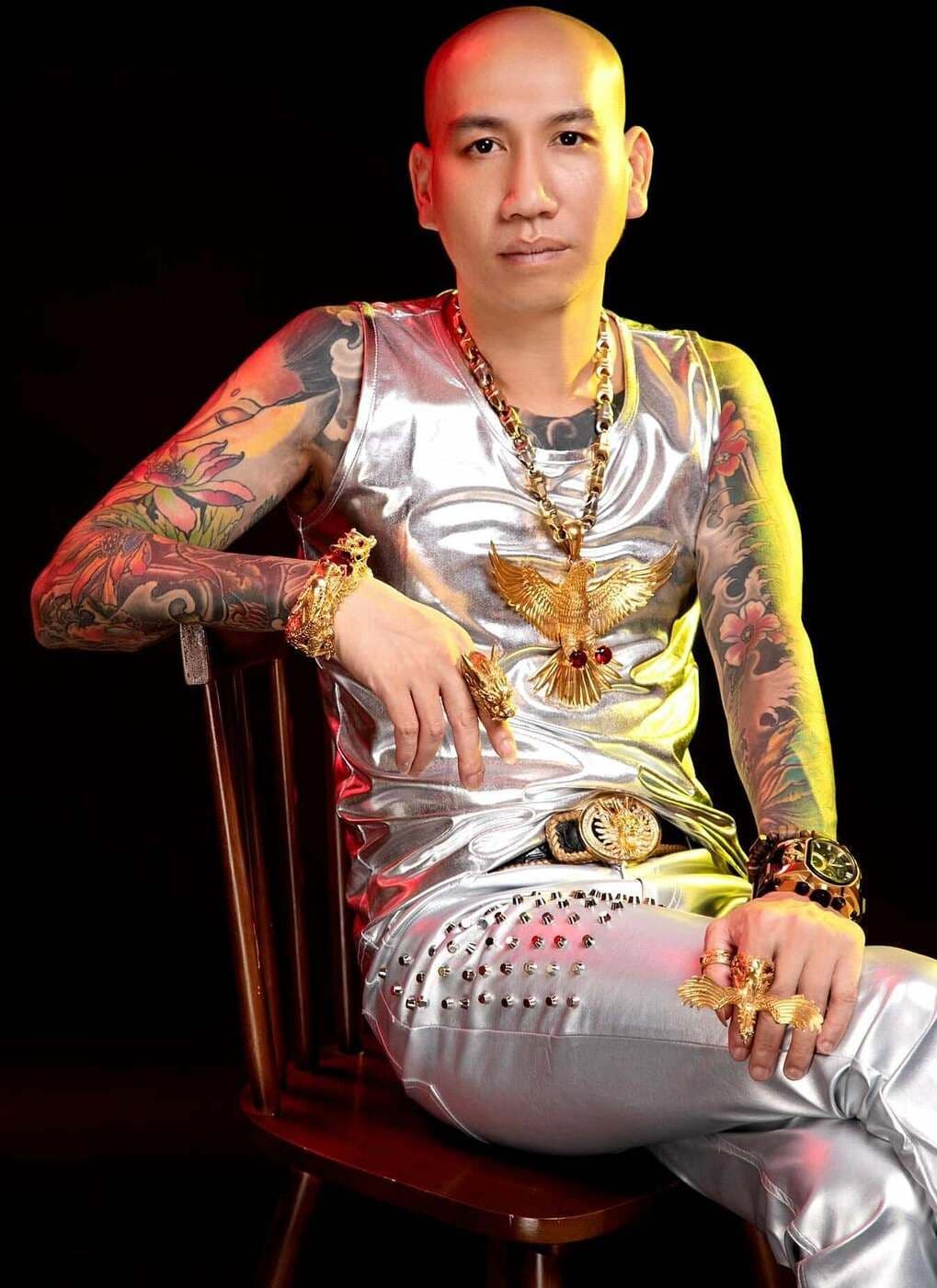 Phú Lê với hình ảnh 'giang hồ mạng' xăm trổ và trang sức vàng hào nhoáng, biểu tượng cho sự nổi tiếng trên mạng xã hội.