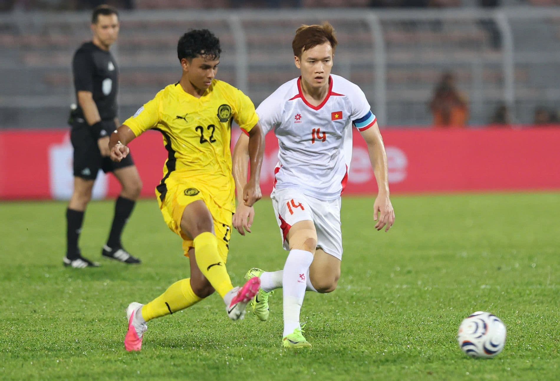 Pha tranh bóng giữa Nguyễn Hoàng Đức và cầu thủ Malaysia trong trận bán kết ASEAN Cup.